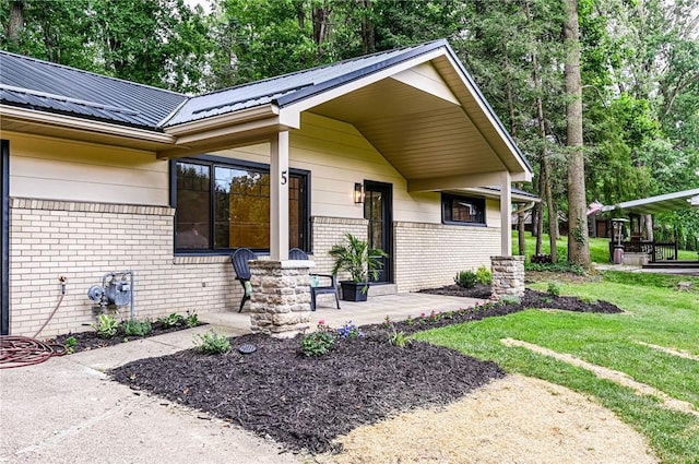 5 Bel Aire Dr, Murrysville, PA 15626 - view of exterior entry featuring brick siding, a lawn, and a metal roof