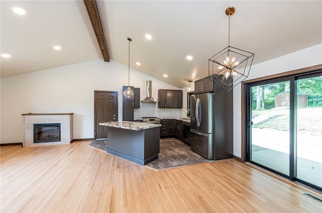 5 Bel Aire Dr, Murrysville, PA 15626 - kitchen with wall chimney range hood, light wood-style floors, tasteful backsplash, appliances with stainless steel finishes, and a kitchen island