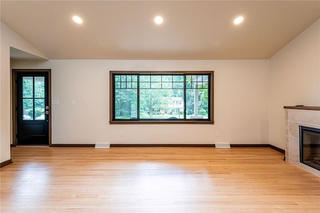 5 Bel Aire Dr, Murrysville, PA 15626 - unfurnished living room featuring plenty of natural light, light wood finished floors, a tile fireplace, recessed lighting, and lofted ceiling