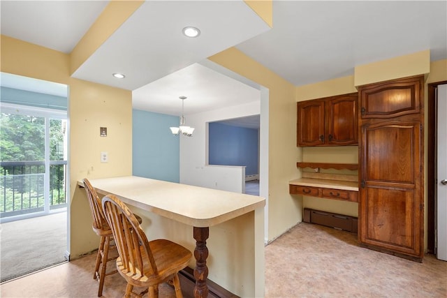1810 Fairland St, Carrick, PA 15210 - kitchen with light countertops, a kitchen bar, a peninsula, decorative light fixtures, and light colored carpet
