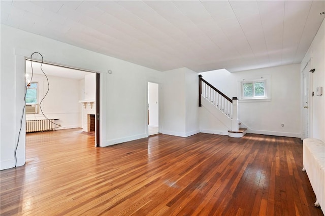 3001 Mount Allister Rd, Observatory Hill, PA 15214 - unfurnished living room with radiator, hardwood / wood-style floors, stairway, and a brick fireplace