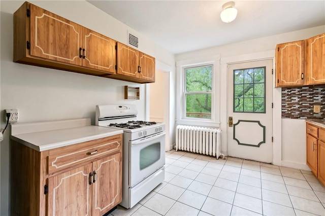 3001 Mount Allister Rd, Observatory Hill, PA 15214 - kitchen with radiator, white gas range, tasteful backsplash, light countertops, and light tile patterned floors