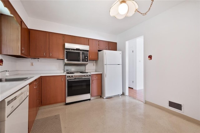 315 Olive St, Mccandless, PA 15237 - kitchen with white appliances, light countertops, brown cabinetry, and a chandelier