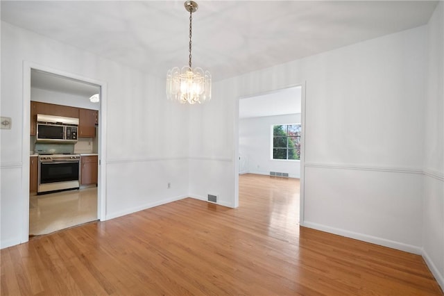315 Olive St, Mccandless, PA 15237 - unfurnished dining area featuring a chandelier and light wood-style floors