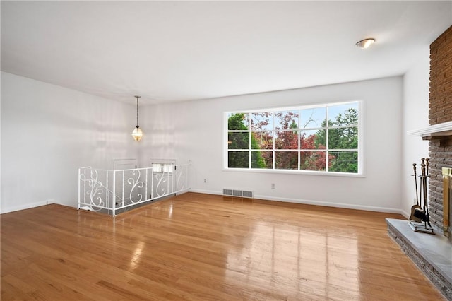 315 Olive St, Mccandless, PA 15237 - unfurnished living room with plenty of natural light, wood finished floors, and a brick fireplace
