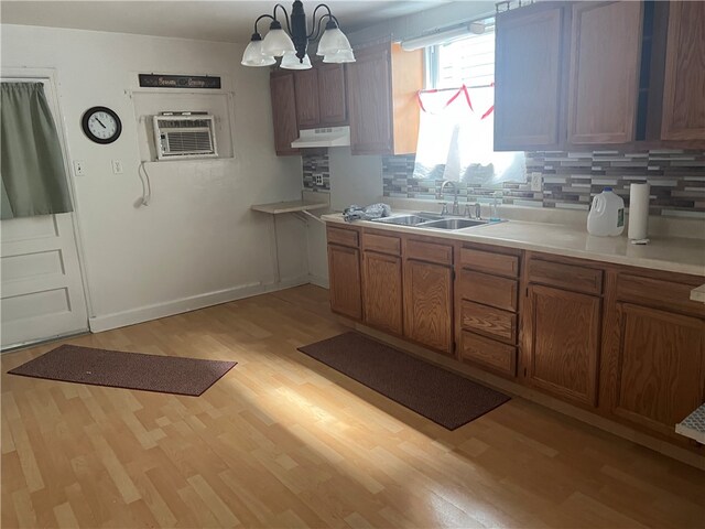121 W Midland Ave, Midland Boro, PA 15059 - kitchen featuring under cabinet range hood, light wood-style flooring, a chandelier, light countertops, and tasteful backsplash