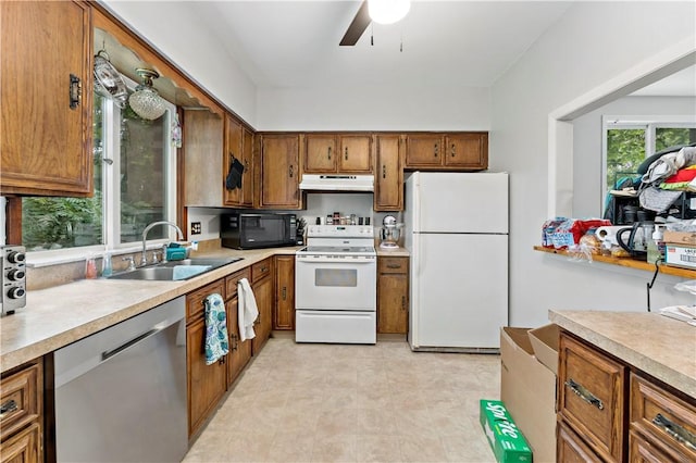 53 Fountain St, Crafton, PA 15205 - kitchen with white appliances, under cabinet range hood, brown cabinetry, and light countertops