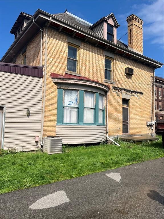214 E Fairview Ave, Connellsville, PA 15425 - rear view of property with brick siding and a chimney