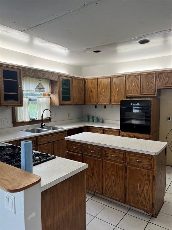 214 E Fairview Ave, Connellsville, PA 15425 - kitchen featuring black appliances, light countertops, light tile patterned floors, and brown cabinetry