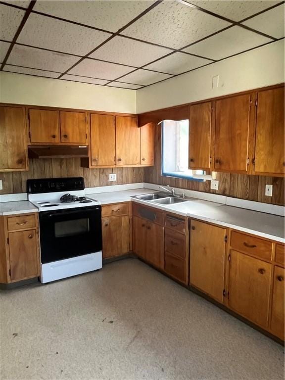 214 E Fairview Ave, Connellsville, PA 15425 - kitchen with white range with electric stovetop, a paneled ceiling, under cabinet range hood, brown cabinetry, and light countertops