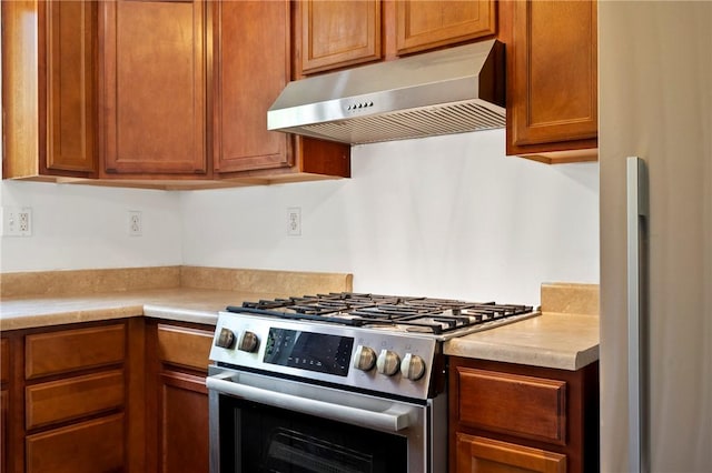 301 N Winebiddle St, Garfield, PA 15224 - kitchen with exhaust hood, appliances with stainless steel finishes, light countertops, and brown cabinets
