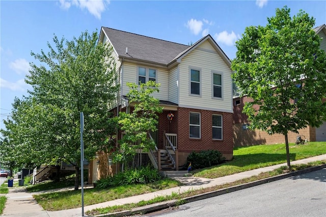 301 N Winebiddle St, Garfield, PA 15224 - traditional-style home featuring stairs, brick siding, a shingled roof, and a front yard