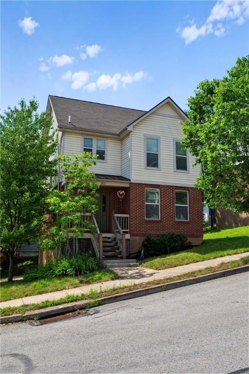 301 N Winebiddle St, Garfield, PA 15224 - view of front facade featuring brick siding and a shingled roof