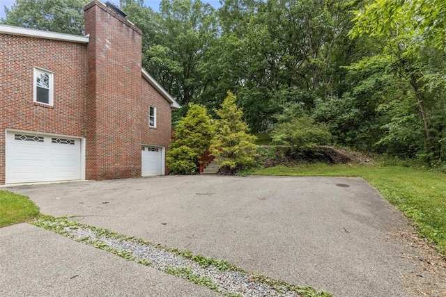 1082 N Boundary, Cranberry Twp, PA 16066 - view of side of property featuring brick siding, a chimney, a garage, and driveway