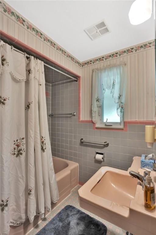 1919 Outlook Dr, Penn Hills, PA 15147 - full bath with tile walls, wallpapered walls, a wainscoted wall, and shower / bath combo