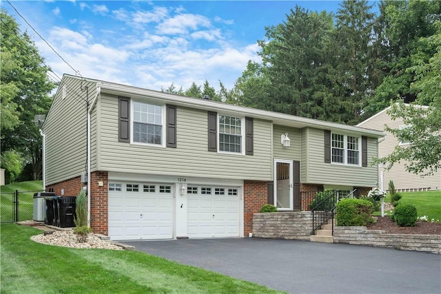 1214 Regency Dr, Mccandless, PA 15237 - split foyer home featuring a garage, asphalt driveway, and brick siding