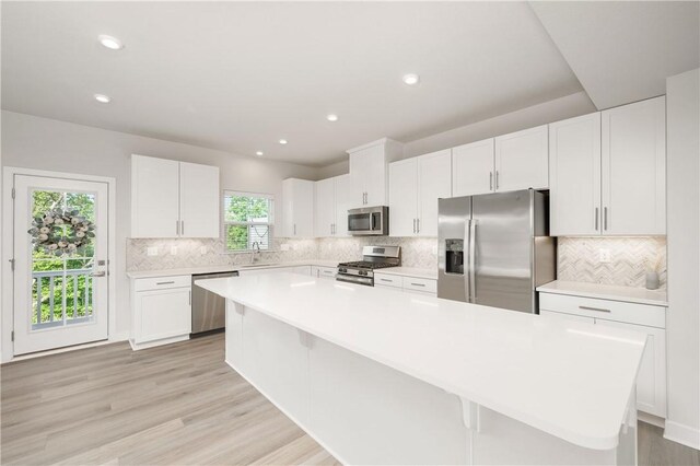 504 Nolan Cir, Cranberry Twp, PA 16066 - kitchen with appliances with stainless steel finishes, light countertops, white cabinetry, backsplash, and a kitchen island