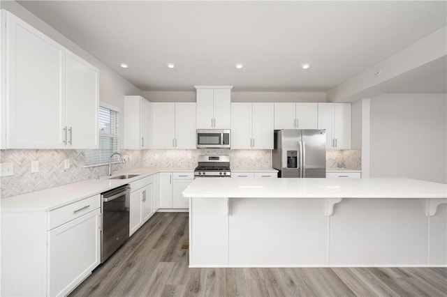 504 Nolan Cir, Cranberry Twp, PA 16066 - kitchen featuring appliances with stainless steel finishes, light wood finished floors, light countertops, a kitchen bar, and tasteful backsplash
