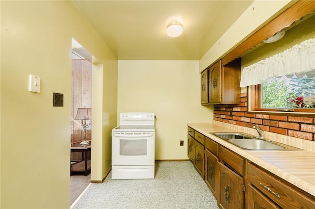 314 N 9th St, Apollo Boro, PA 15613 - kitchen with white range with electric stovetop, light colored carpet, light countertops, decorative backsplash, and brown cabinetry