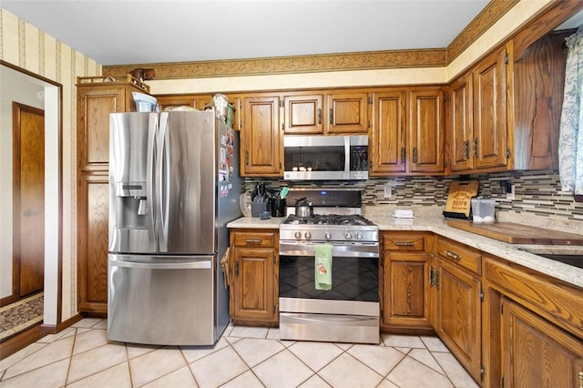 334 Park St, North Union Twp, PA 15401 - kitchen with appliances with stainless steel finishes, brown cabinetry, light tile patterned floors, and wallpapered walls