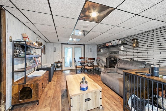 334 Park St, North Union Twp, PA 15401 - living room featuring hardwood / wood-style flooring, a paneled ceiling, brick wall, and wood walls