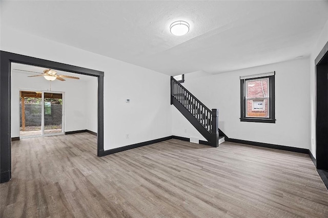1462 Elm St, Wilkinsburg, PA 15221 - unfurnished living room featuring wood finished floors, stairway, and ceiling fan