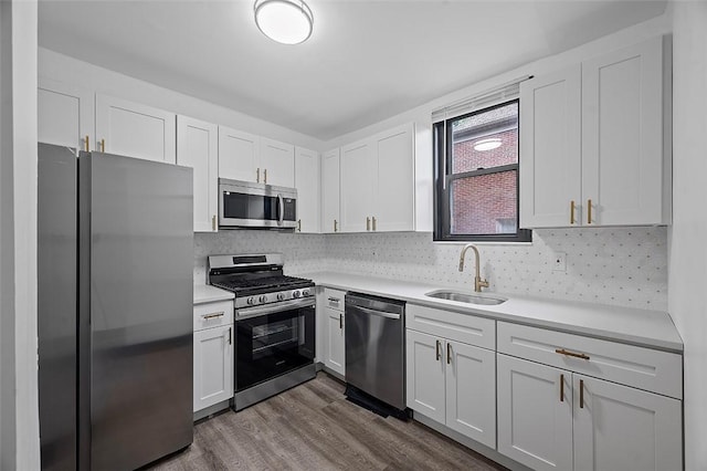 1462 Elm St, Wilkinsburg, PA 15221 - kitchen with stainless steel appliances, light countertops, dark wood-style flooring, and white cabinetry