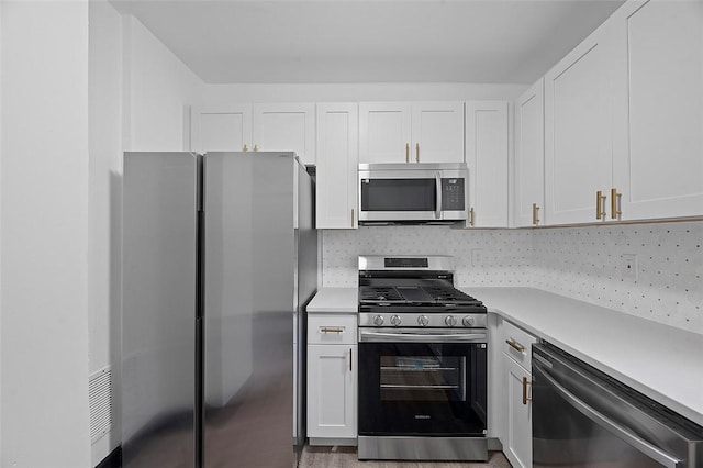 1462 Elm St, Wilkinsburg, PA 15221 - kitchen with stainless steel appliances, light countertops, white cabinets, and backsplash
