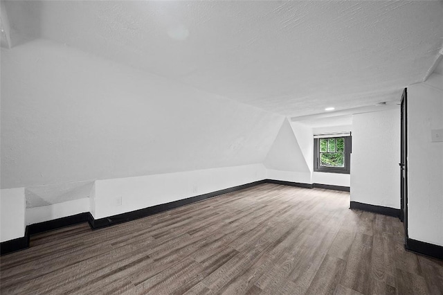 1462 Elm St, Wilkinsburg, PA 15221 - bonus room featuring wood finished floors, vaulted ceiling, and a textured ceiling
