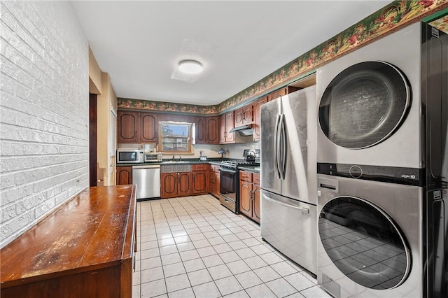 1860 Jancey St, Morningside, PA 15206 - kitchen with stacked washer / drying machine, stainless steel appliances, dark countertops, under cabinet range hood, and light tile patterned floors