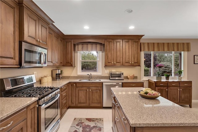 2899 E Elfinwild Rd, Hampton, PA 15101 - kitchen with appliances with stainless steel finishes, light stone counters, brown cabinets, a kitchen island, and recessed lighting