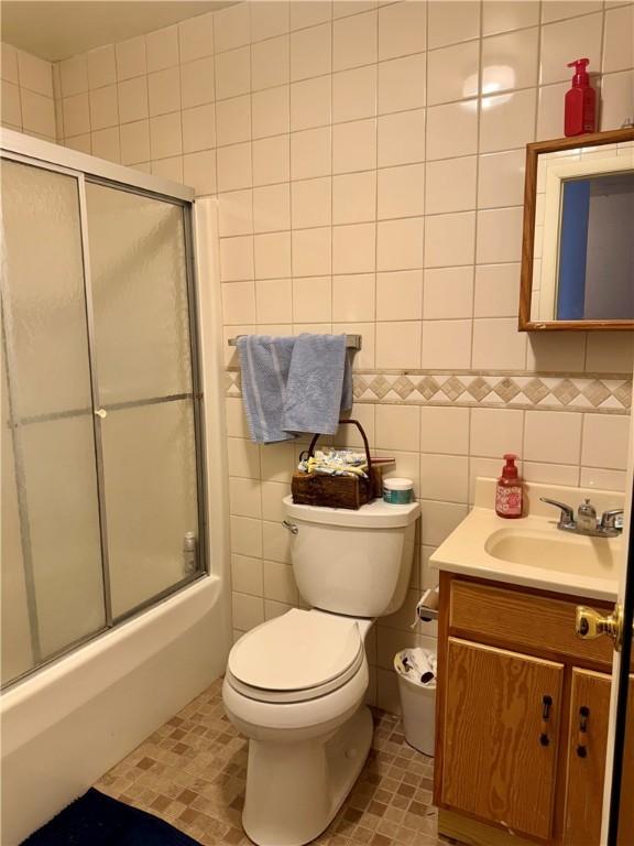 250 E Water St, Slippery Rock Boro, PA 16057 - full bathroom with tile walls, vanity, bath / shower combo with glass door, and tile patterned floors