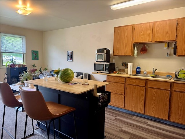 250 E Water St, Slippery Rock Boro, PA 16057 - kitchen featuring stainless steel microwave, a breakfast bar area, wood finished floors, a center island, and brown cabinetry