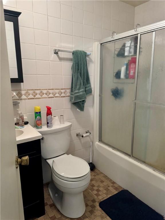 250 E Water St, Slippery Rock Boro, PA 16057 - full bath featuring vanity, combined bath / shower with glass door, and tile walls