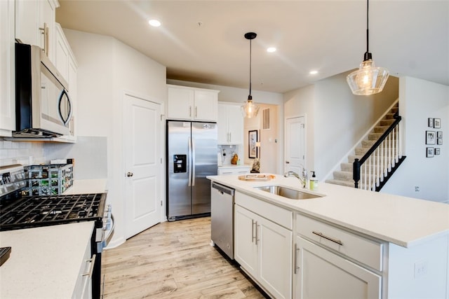 326 Stately Ct, Adams Twp, PA 16046 - kitchen featuring appliances with stainless steel finishes, white cabinets, light wood-style flooring, backsplash, and pendant lighting