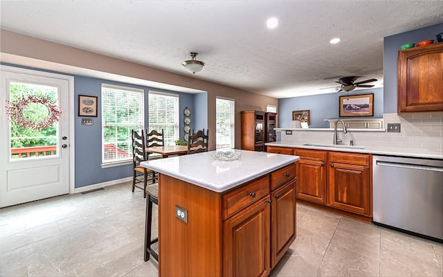 489 Jenny Dr, Richland, PA 15044 - kitchen featuring stainless steel dishwasher, a textured ceiling, a breakfast bar, light countertops, and a kitchen island