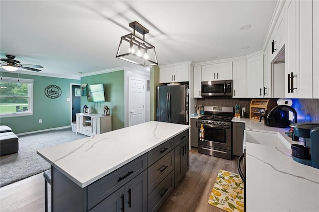 4 Ward St, Canton Twp, PA 15301 - kitchen featuring appliances with stainless steel finishes, white cabinetry, a kitchen island, ceiling fan, and decorative backsplash
