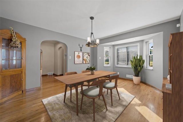 7604 Tyler Rd, Verona, PA 15147 - dining space with arched walkways, healthy amount of natural light, light wood-type flooring, and a chandelier