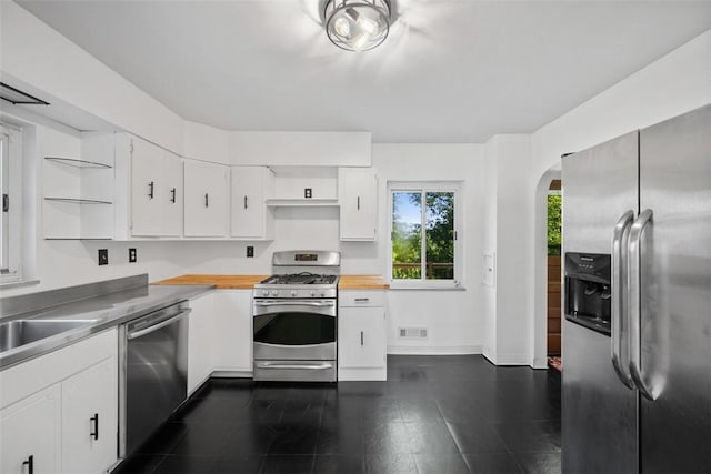7604 Tyler Rd, Verona, PA 15147 - kitchen featuring stainless steel counters, appliances with stainless steel finishes, arched walkways, white cabinetry, and open shelves