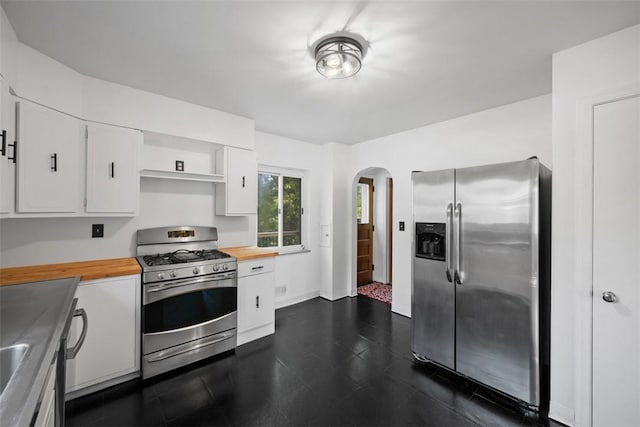 7604 Tyler Rd, Verona, PA 15147 - kitchen featuring appliances with stainless steel finishes, wood counters, arched walkways, and white cabinetry