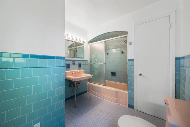 7604 Tyler Rd, Verona, PA 15147 - full bathroom featuring tile walls, tile patterned flooring, shower / bath combination with glass door, wainscoting, and pet washing area