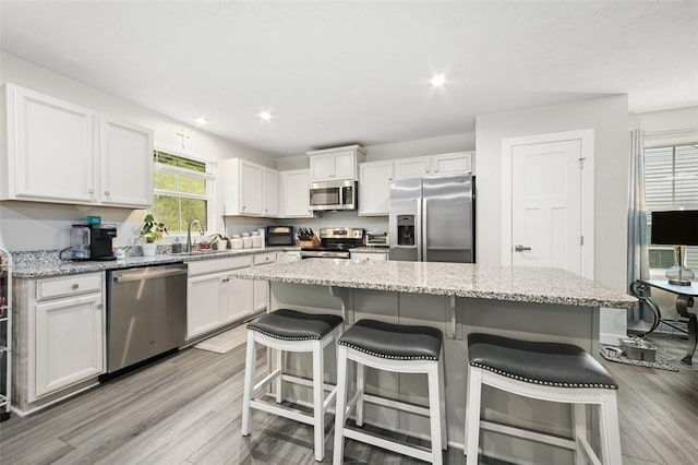 329 Nelson Dr, Monroeville, PA 15146 - kitchen featuring appliances with stainless steel finishes, white cabinetry, light wood-style floors, recessed lighting, and a breakfast bar
