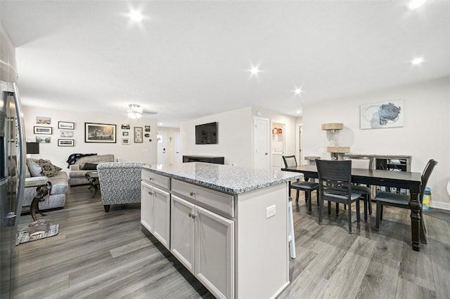329 Nelson Dr, Monroeville, PA 15146 - kitchen featuring a center island, light wood-style flooring, open floor plan, light stone countertops, and recessed lighting