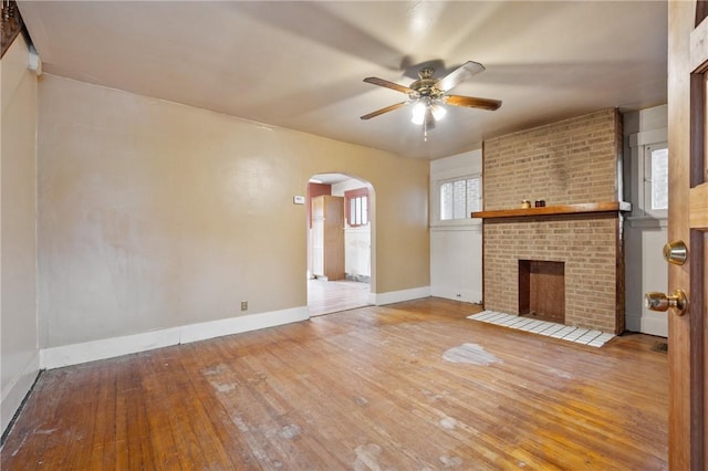1477 Benton Ave, Brighton Heights, PA 15212 - unfurnished living room with arched walkways, wood-type flooring, ceiling fan, and a brick fireplace