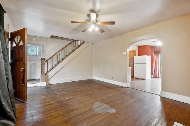 1477 Benton Ave, Brighton Heights, PA 15212 - unfurnished living room featuring ceiling fan, arched walkways, hardwood / wood-style flooring, and stairs