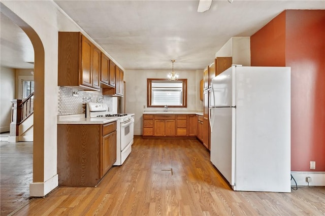 1477 Benton Ave, Brighton Heights, PA 15212 - kitchen with white appliances, light wood finished floors, arched walkways, and plenty of natural light