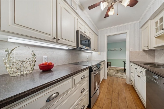 53 Highland Rd Unit 403-404, Bethel Park, PA 15102 - kitchen featuring stainless steel appliances, dark countertops, ornamental molding, ceiling fan, and light wood-type flooring