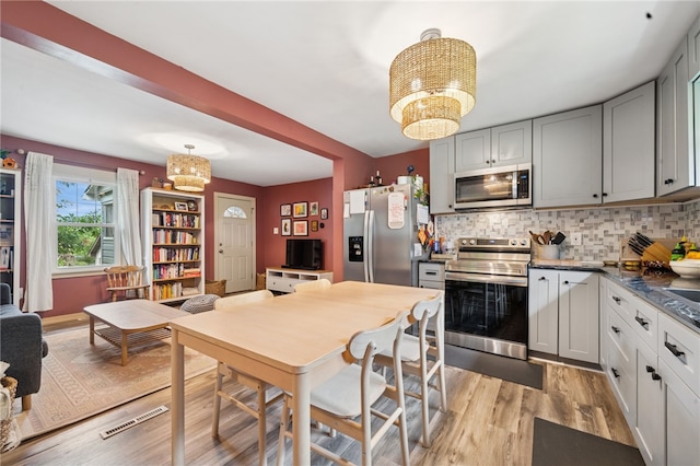 1021 Beechnut St, West Deer, PA 15084 - kitchen featuring stainless steel appliances, a chandelier, light wood-type flooring, decorative backsplash, and gray cabinetry