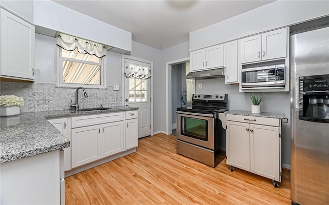 112 Fisk Ave, Avalon, PA 15202 - kitchen featuring stainless steel appliances, under cabinet range hood, light wood-style flooring, light stone counters, and white cabinets