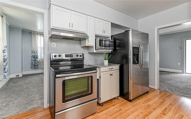 112 Fisk Ave, Avalon, PA 15202 - kitchen with stainless steel appliances, under cabinet range hood, white cabinetry, light carpet, and ornamental molding